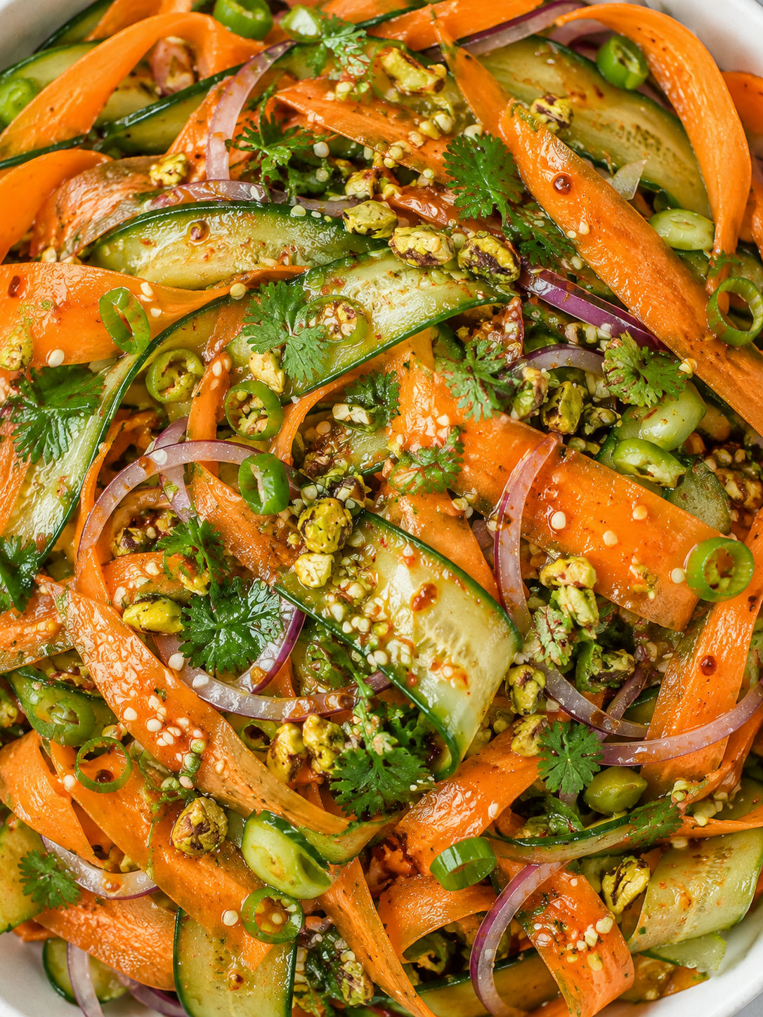 Asian cucumber carrot ribbon salad filling a white bowl