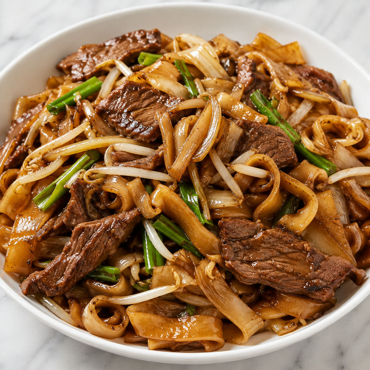 Beef chow fun with wide rice noodles, tender beef, sprouts, and scallions