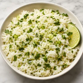 Cilantro lime rice with fresh cilantro and lime in a white bowl