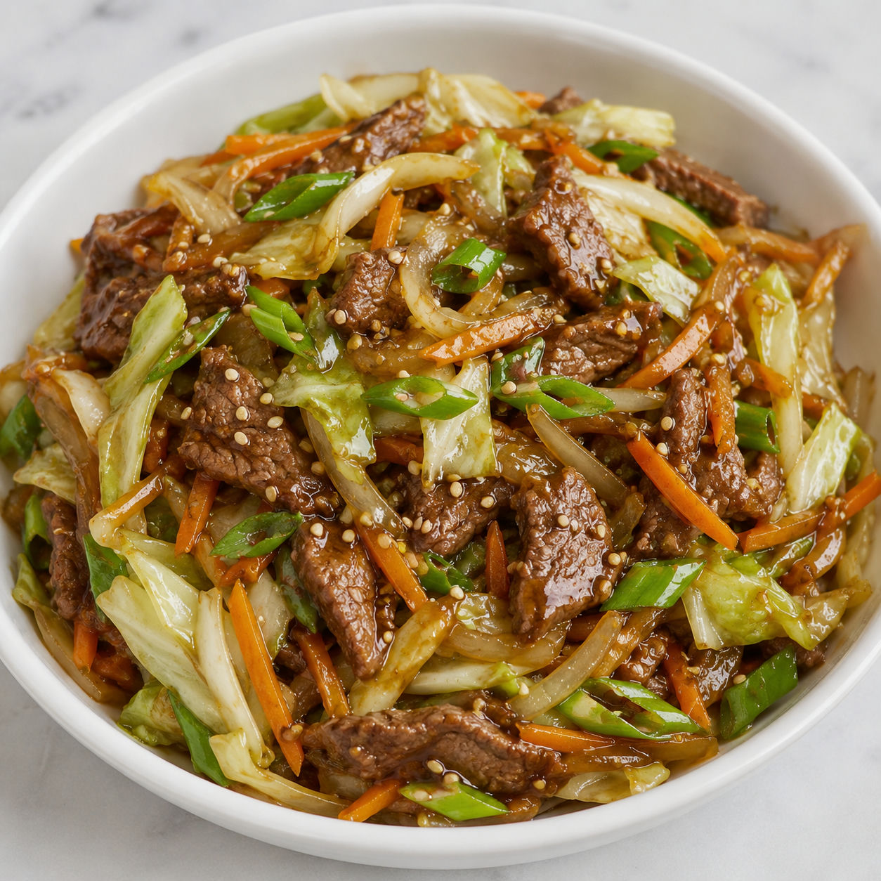 Beef cabbage stir-fry with carrots, green onions, and sesame seeds