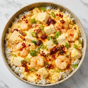 Silken tofu eggs and shrimp over rice with chili sauce and green onions