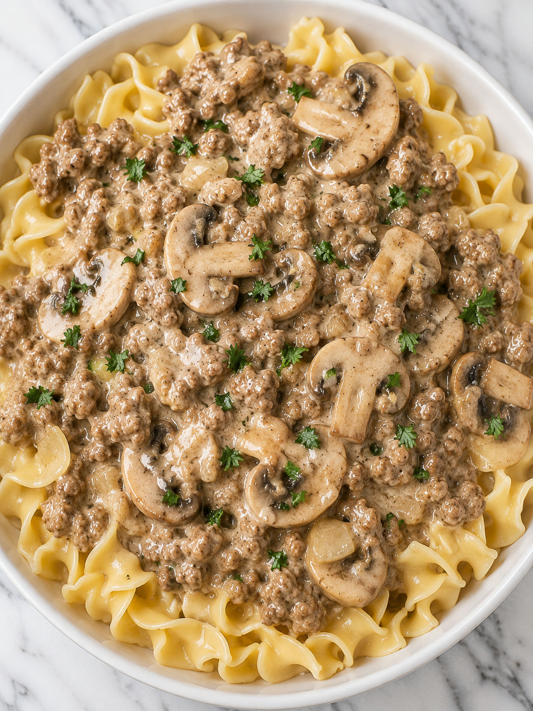 Bowl of creamy ground beef stroganoff with egg noodles and parsley