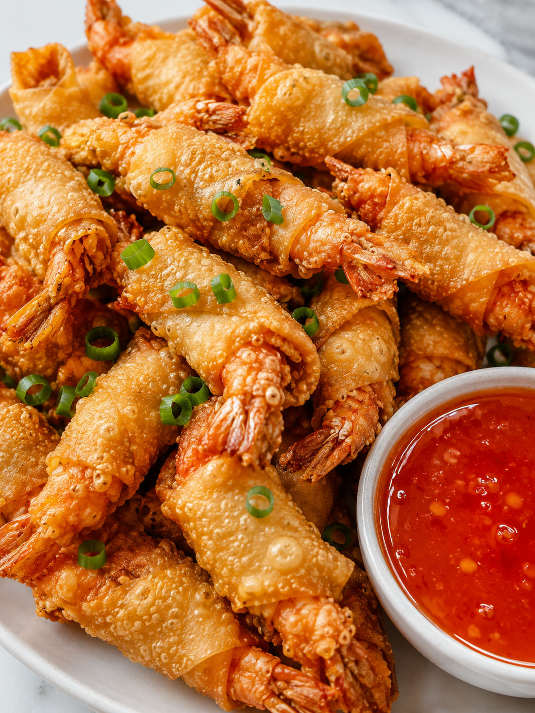Crispy wonton shrimp piled with sweet chili sauce and green onions