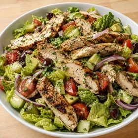 Grilled chicken salad with avocado, tomatoes, olives, and lemon dressing