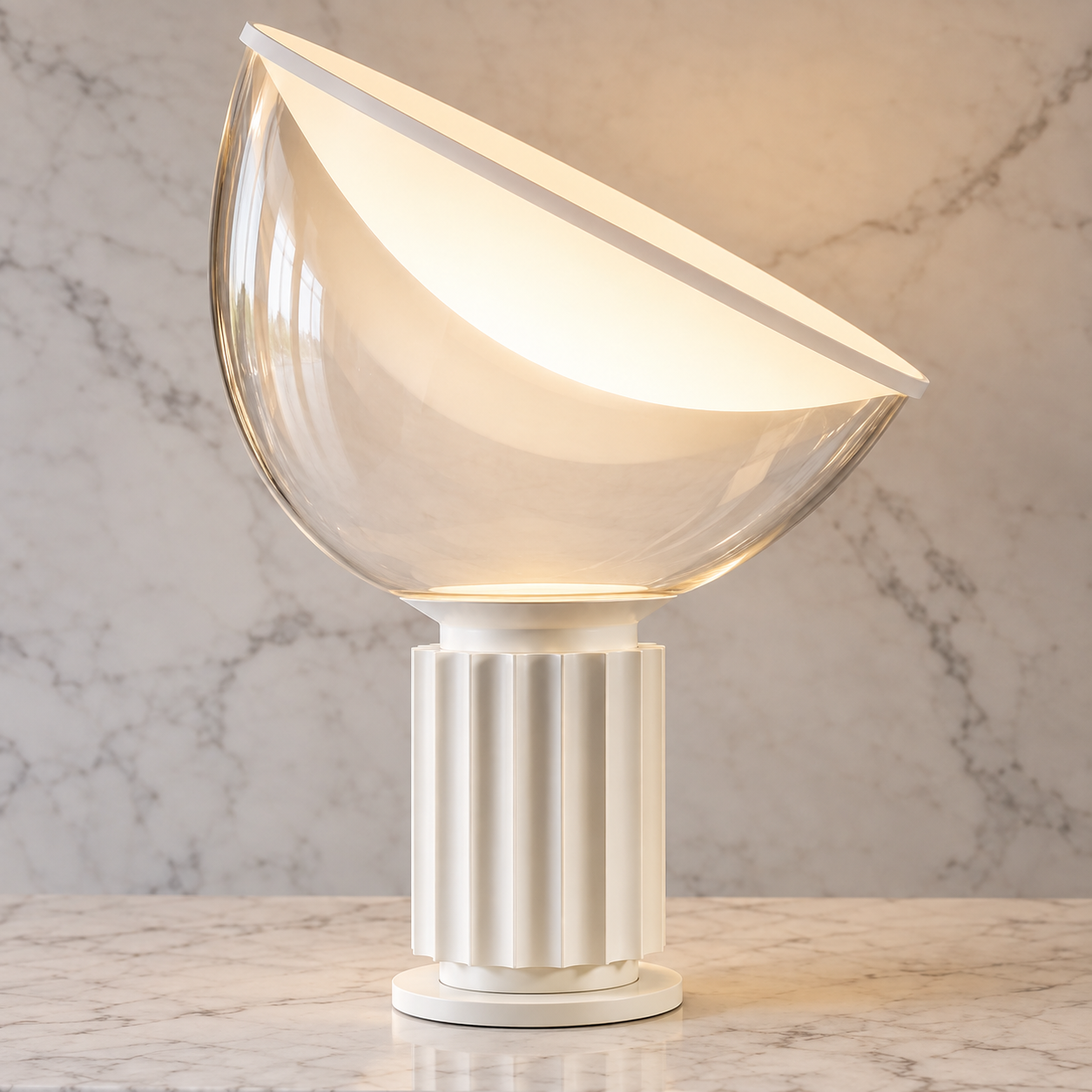 Matte white Taccia table lamp glowing on a pale stone console