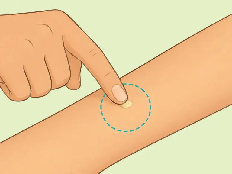 A fingertip applying a tiny patch test of balm to the forearm.